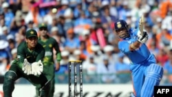 Pakistan wicketkeeper Kamran Akmal (left) looks on as Sachin Tendulkar hits a boundary during the Cricket World Cup semifinal between India and Pakistan in 2011. India went on to win the tournament.