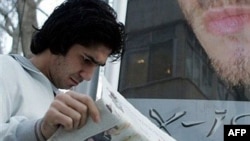 Iran -- An Iranian man reads a newspaper featuring a picture of three of the captured British sailors, Tehran, 03Apr2007