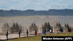 Руски, кинески и монголски трупи и воена опрема парадираат на крајот од воените вежби „Восток-2018“ недалеку од кинеско-монголската граница во Сибир во септември 2018 година.