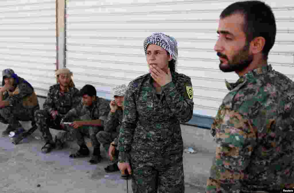 Syria -- A commander of Kurdish fighters from the People's Protection Units (YPG) listens to her comrades in Raqqa, June 15, 2017