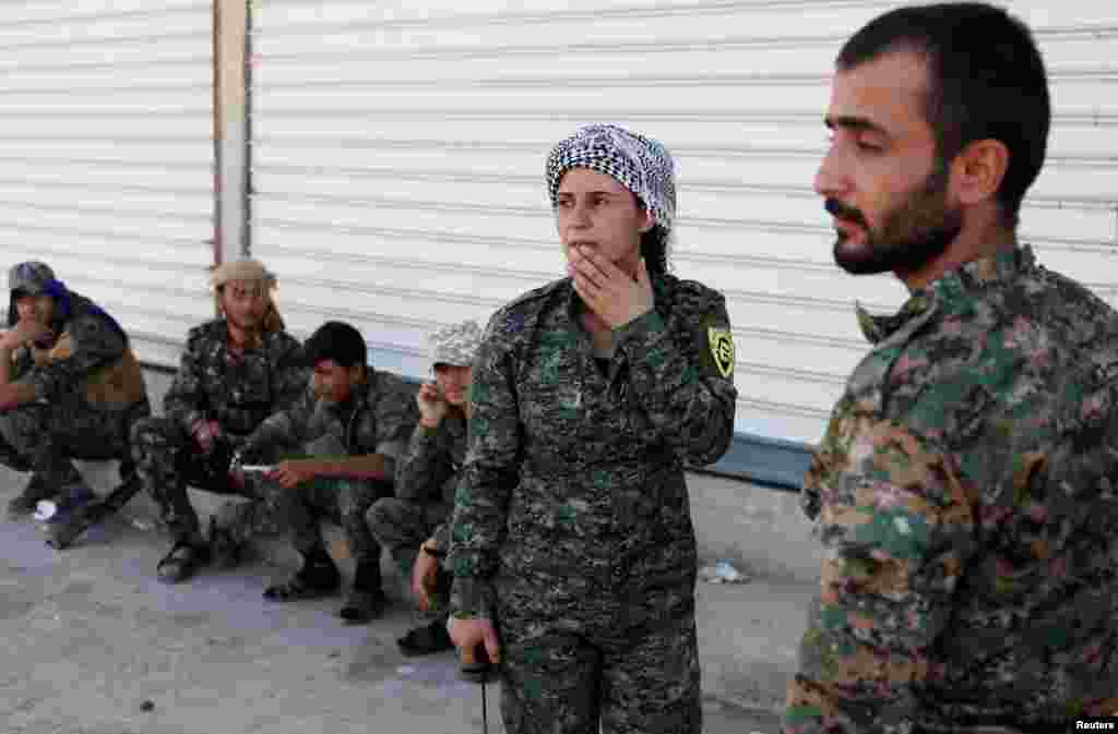 Syria -- A commander of Kurdish fighters from the People's Protection Units (YPG) listens to her comrades in Raqqa, June 15, 2017