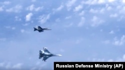 Винищувач Су-27 російських ВПС (знизу) маневрує на тлі військового літака НАТО F-18 над Балтійським морем, архівне фото, 2019 рік