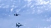 Un avion militar rus Su-27 (jos) face manevre sub un avion NATO F-18 deasupra Mării Baltice