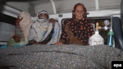 Таспен ұрып өлтірілген Фарзананың туыстары оның мәйітінің қасында отыр. Пәкістан, Лахор, 27 мамыр 2014 жыл. 