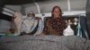 Relatives sit beside the body of Farzana Iqbal (nee Parveen), who was stoned to death by members of her family for marrying against their wishes, in Lahore on May 27.