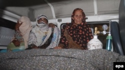 Relatives sit beside the body of Farzana Iqbal (nee Parveen), who was stoned to death by members of her family for marrying against their wishes, in Lahore on May 27.