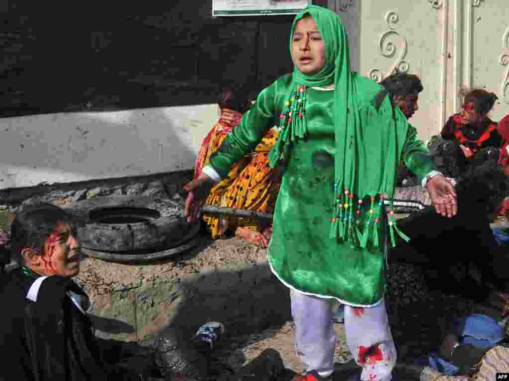 Shi'a Muslims surrounded by the dead and injured react following a bomb attack on a Shi'ite religious ceremony in the center of Kabul on December 6. (Photo for AFP by Massoud Hossaini)