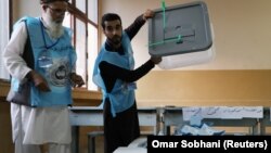 یک کارمند کمیسیون انتخابات اوراق رأی‌دهی یکی از مراکز کابل را جهت شمارش از بکس بیرون کرده است. September 28, 2019