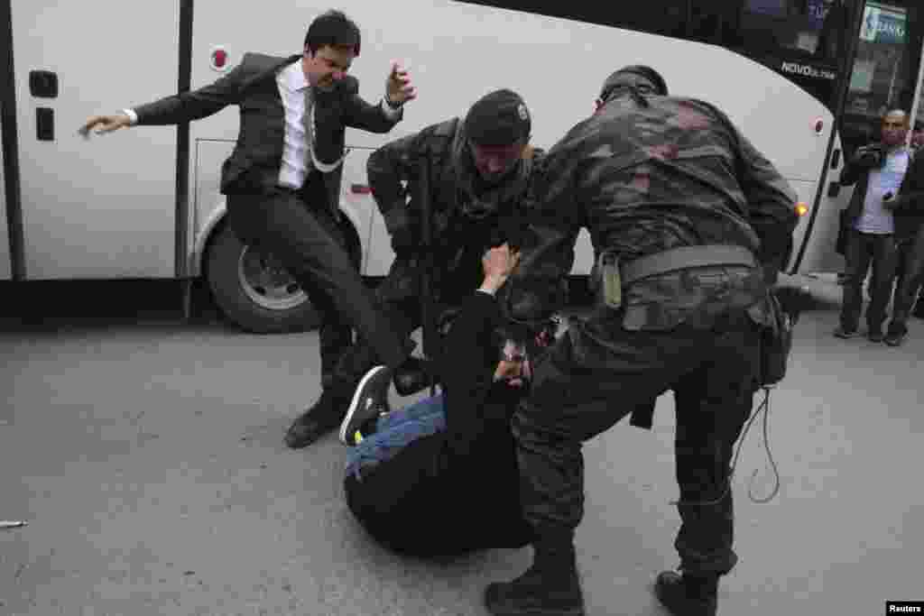 As police officers detain him, a protester is kicked by Yusuf Yerkel (left), advisor to Prime Minister Tayyip Erdogan, during a protest against Erdogan&#39;s visit to Soma, a district in western province of Manisa, where hundreds of miners died in an explosion this week. (Reuters/Mehmet Emin)