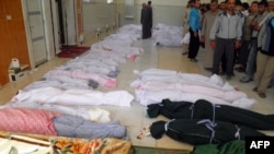 A handout picture released by the Syrian opposition's Shaam News Network shows the shrouded bodies of 92 people, including 32 children, before their burial in the town of Houla on May 26.