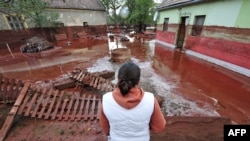 A woman looks at the damage in Devecser, Hungary, on October 5.