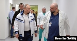 No masks: Russian President Vladimir Putin (left) speaks with chief physician Denis Protsenko during a visit to the country's primary hospital for COVID-19 patients on the outskirts of Moscow on March 24, 2020.