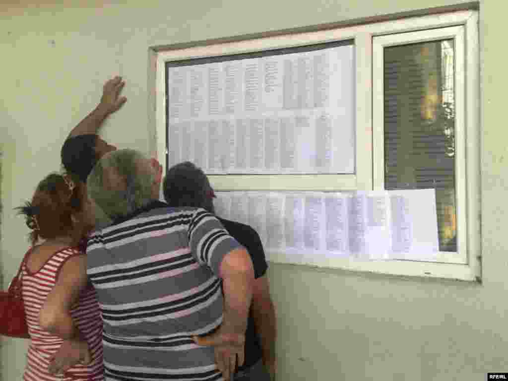 Местные жители ищут имена своих родственников в списках погибших в госпитале в Гори. 12 августа 2008 года.