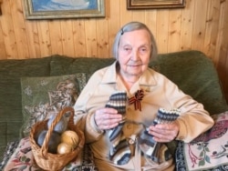 Korneva holds the socks she knitted for Tom Moore of England, “with love from Russia.”