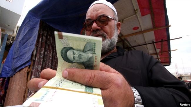 A man buys Iranian rials from a seller of Iranian currency, before the start of the U.S. sanctions on Tehran, in Basra, Iraq November 3, 2018. Picture taken November 3, 2018. REUTERS/Essam al-Sudani