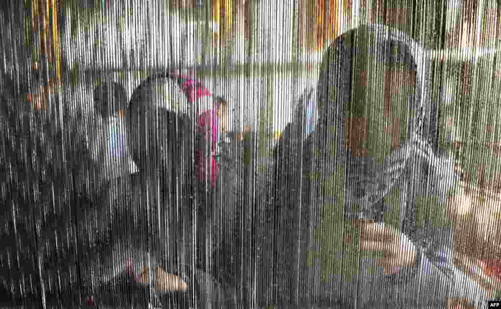 بچه های خردسال در حال بافتن فرش در هرات، افغانستان