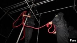 Police officers prepare a rope ahead of a public hanging in Iran. 