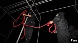 Iranian police officers prepare a hanging rope. 