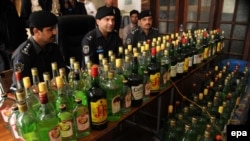 Пакистанские полицейские демонстрируют изъятую алкогольную продукцию. 20 марта 2013 года.