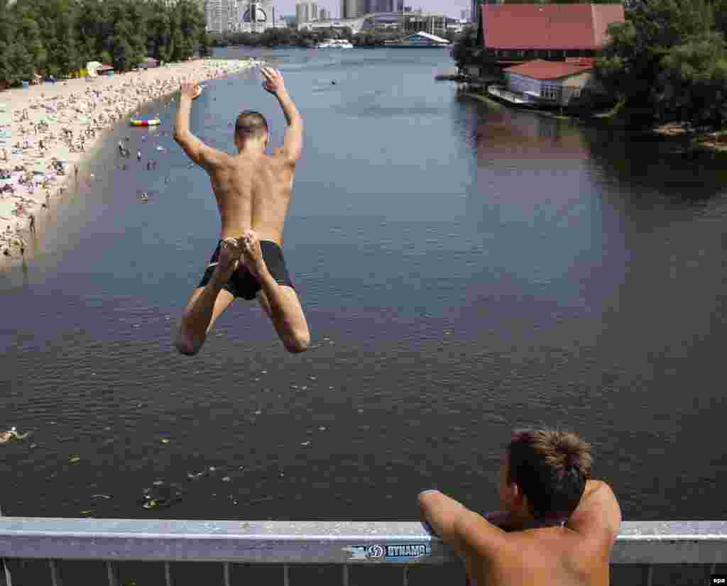 A boy jumps from a bridge into the Dnipro River to cool off in Kyiv, Ukraine. (epa/Roman Pilipey)