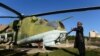 Museum assistant and former Soviet soldier, Sheikh Abdullah, formally known as Bakhretdin Khakimov, stands alongside a Soviet helicopter at the Jihad Museum.