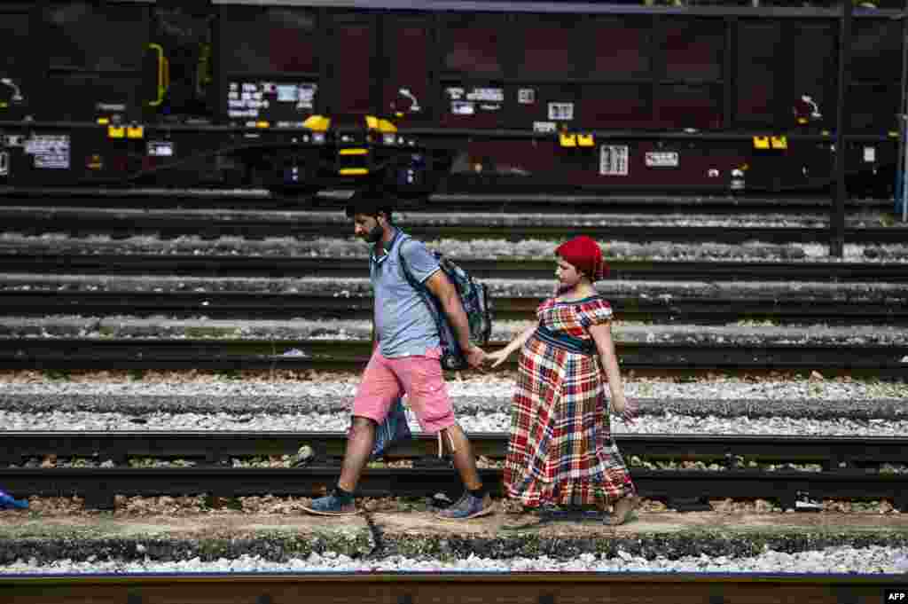 A Syrian migrant and his pregnant wife walk on train tracks towards the town of Gevgelija, on the Macedonian-Greek border. (AFP/Dimitar Dilkoff) 