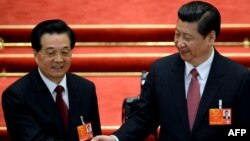 Newly elected President Xi Jinping (right) shakes hands with former President Hu Jintao after Xi was also elected as chairman of the Central Military Commission during the 12th National People's Congress in Beijing on March 14.