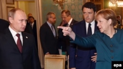 Президент РФ Владимир Путин и канцлер ФРГ Ангела Меркель, в глубине – премьер-министр Италии Маттео Ренци (в кулуарах саммита АСЕМ в Милане (17 октября 2014 года)