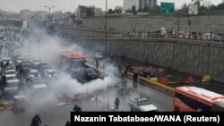 Riot police triy to disperse people as they protest on a highway against increased gas price in Tehran, Iran November 16, 2019.