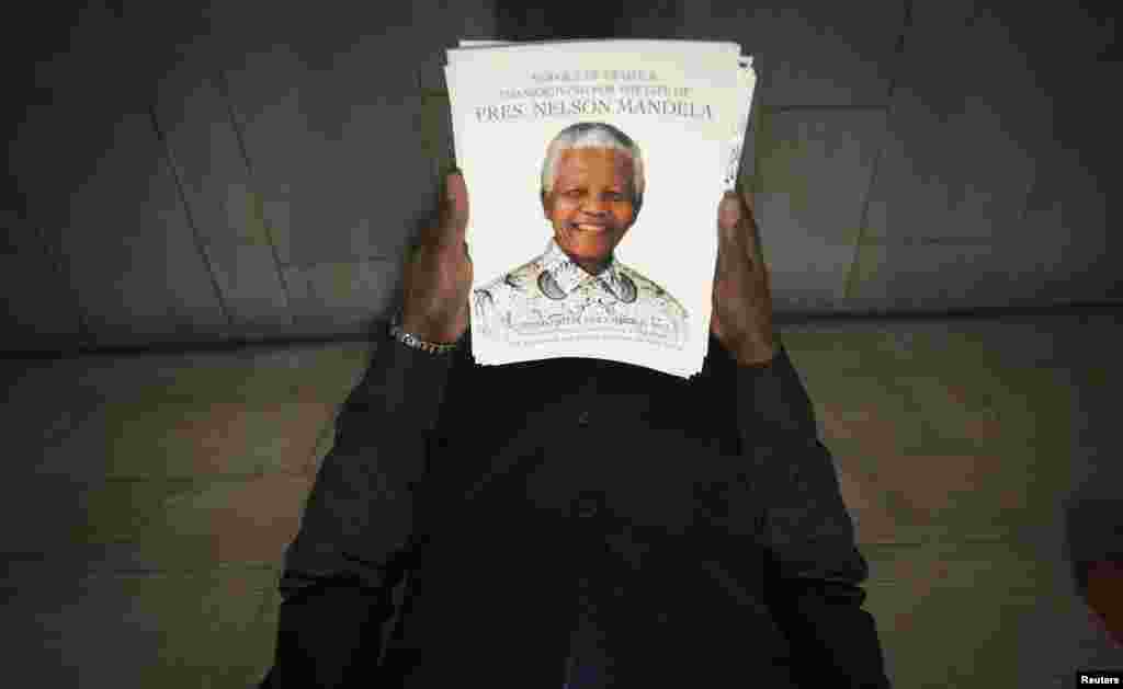 An usher holds programs with the image of Nelson Mandela on the cover before a memorial service for the late South African antiapartheid icon&nbsp;at the Riverside Church in New York. (Reuters/Carlo Allegri)