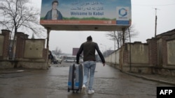 An Afghan migrant who was deported from Germany arrives with his belongings at the international airport in Kabul. (file photo)