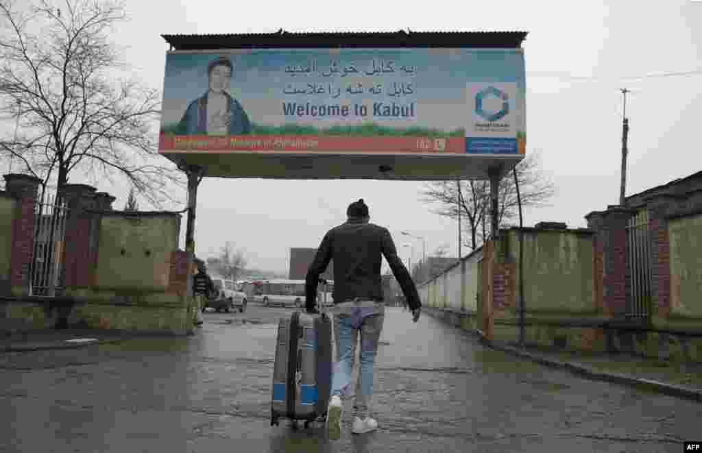 An Afghan refugee who was deported from Germany arrives with his belongings at the international airport in Kabul. (AFP/Wakil Kohsar)