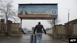 An Afghan refugee who was deported from Germany arrives with his belongings at the international airport in Kabul on January 24.