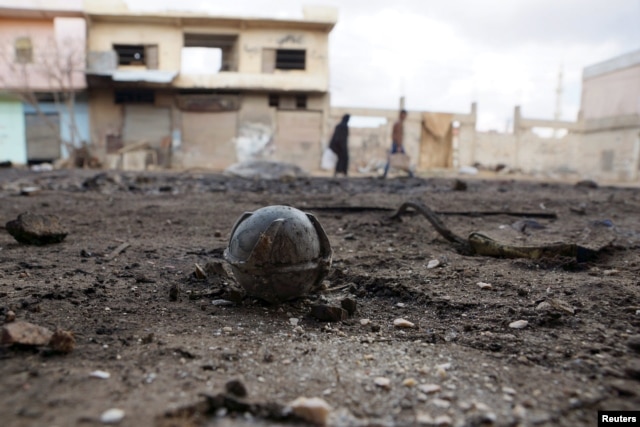 An unexploded cluster bomblet is seen along a street after air strikes by pro-Syrian forces in the rebel held town of al-Ghariyah al-Gharbiyah in Deraa Province on February 11.2016