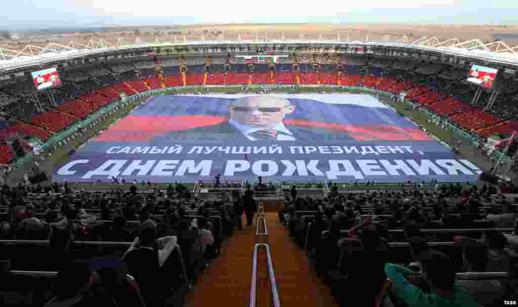 A giant banner measuring 105-by-68 meters with a portrait of Vladimir Putin is unfurled at Akhmat Arena Stadium during celebrations marking the 63rd birthday of the Russian president in Grozny. (TASS/Magomed Khadisov)