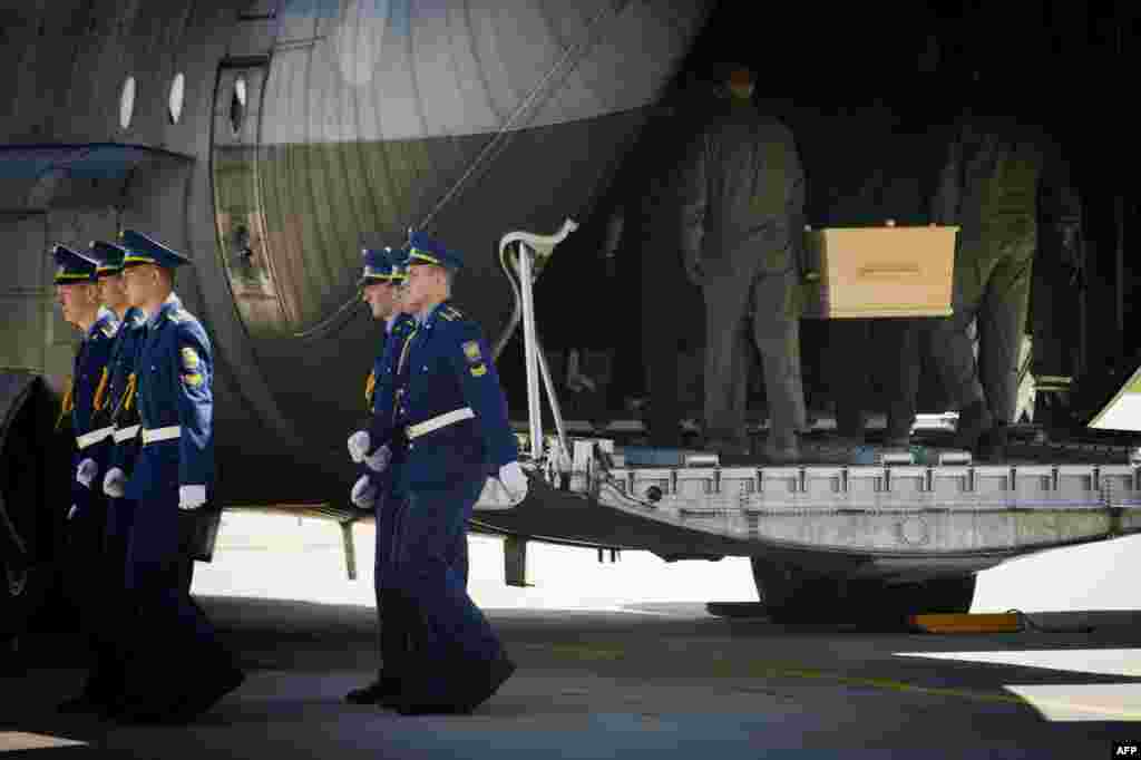 Coffins holding the remains of some the victims of Malaysia Airlines Flight MH17, downed over rebel-held territory in eastern Ukraine on July 17, are loaded onto a transport plane bound for the Netherlands at Kharkiv airport on July 23. (AFP/Jan Daniels)