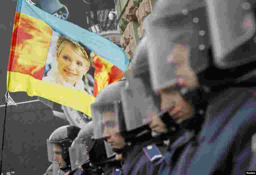 Ukrainian riot police block opposition supporters carrying a flag with a portrait of the jailed former prime minister, Yulia Tymoshenko, from entering city hall during a rally in Kyiv on October 23. (Reuters/Gleb Garanich)