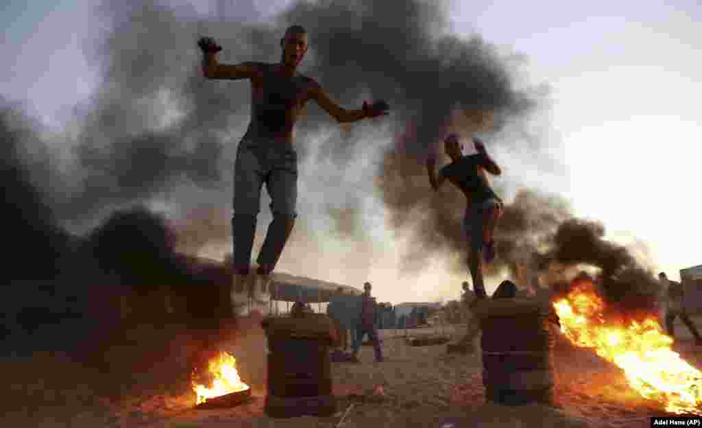Palestinian students jump over burning tires in a display of their military skills at the Al-Rebat College for Law and Police Science in Khan Younis in the southern Gaza Strip. (AP/Adel Hana)