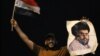 An Iraqi man in Baghdad celebrates with a picture of Shi'ite cleric Muqtada al-Sadr following his strong showing in Iraq's general election earlier this month. 