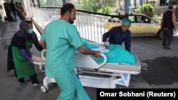 A wounded woman arrives for treatment at a hospital after a blast in Kabul on July 25.