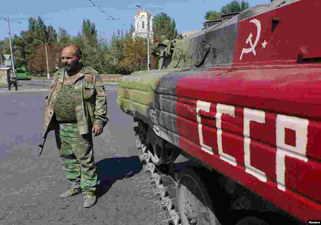 A pro-Russian separatist stands next to an armored personnel carrier freshly painted with the communist hammer and sickle and the Cyrillic abbreviation for the Soviet Union in the eastern Ukrainian city of Donetsk on September 2. (Reuters/Maxim Shemetov) 