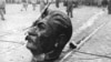 Голова с поверженной статуи советского лидера Иосифа Сталина на улице Будапешта после того, как митингующие разрушили его памятник в ходе Венгерской революции в 1956 году