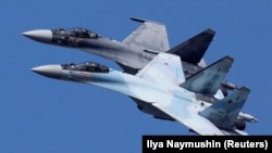 Avioanele de luptă Sukhoi Su-35 ale echipei de acrobație acrobatică „Sokoly Rossii” zboară în formație în timpul unei repetiții pentru show-ul aerian de la Krasnoyarsk, Rusia, 1 august 2019.