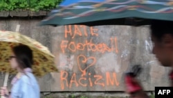 Львов қаласының көшесінде "Hate football, love racizm" ("Футболды жек көр, расизмді жақсы көр") деп жазулы тұр. Украина, 1 маусым 2012 жыл.