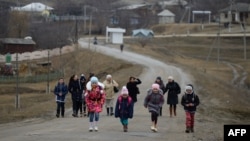 Copii și profesori, întorcându-se acasă de la școală în satul Bumbăta