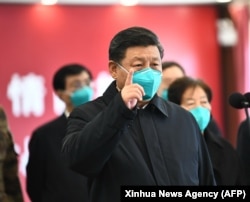 Chinese President Xi Jinping gestures to a coronavirus patient and medical staff via video link at the Huoshenshan hospital in Wuhan in March 2020.