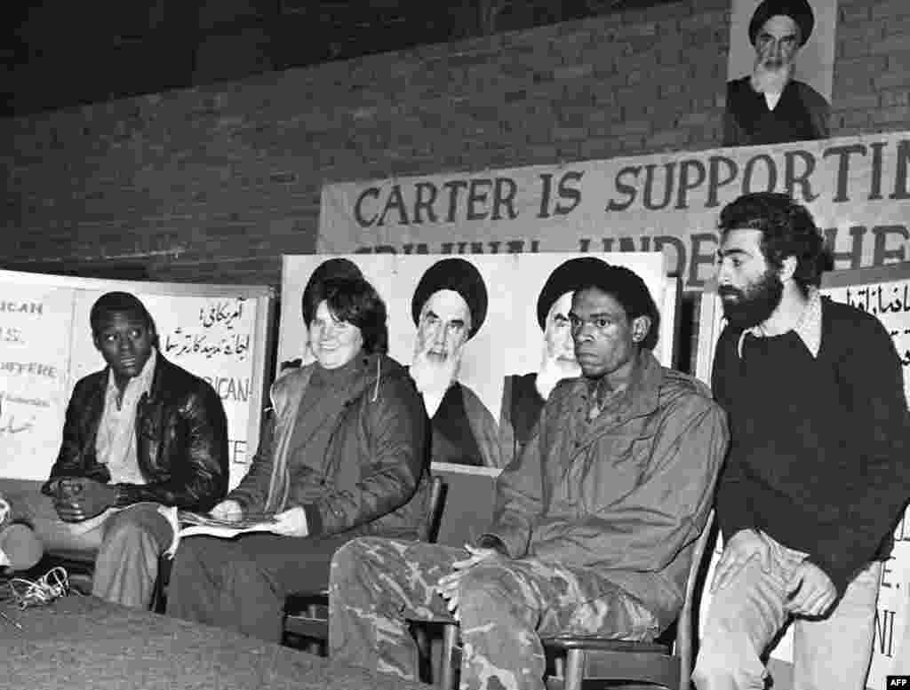 Iran -- Three unidentified US hostages speak to the press while their Iranian captor (R) watches closely, at the besieged US embassy in Tehran, Nov1979 - IRAN, Tehran : (FILES) Three unidentified US hostages speak to the press while their Iranian captor (R) watches closely, at the besieged US embassy in Tehran, November 1979. Twenty years on, the anniversary 04 November of the hostage-taking is still marked by mass anti-US demonstrations in the Islamic republic.