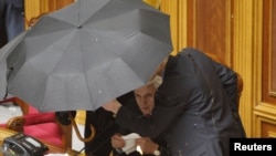 Голова Верховної Ради Володимир Литвин під прикриттям парасольок оголошує про ратифікацію «харківських угод». Парламент України, 27 квітня 2010 року