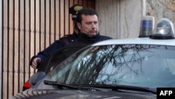 "Costa Concordia" Captain Francesco Schettino is escorted into custody by a policeman in Grosseto on January 14, one day after the tragedy.