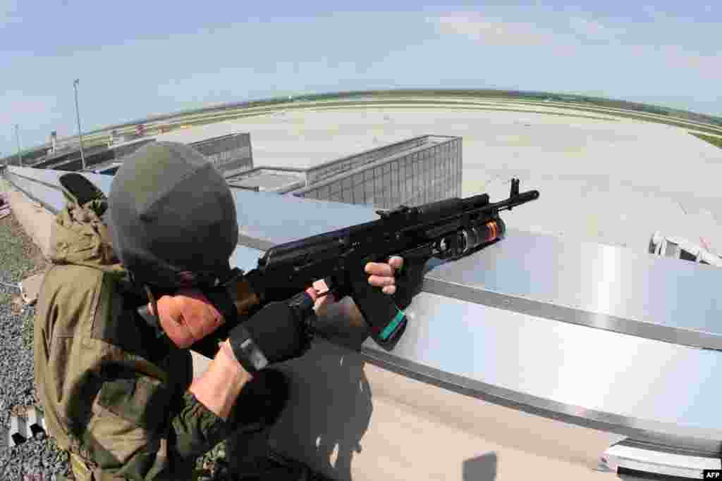 A pro-Russian militant takes up a position atop the Donetsk airport's roof.